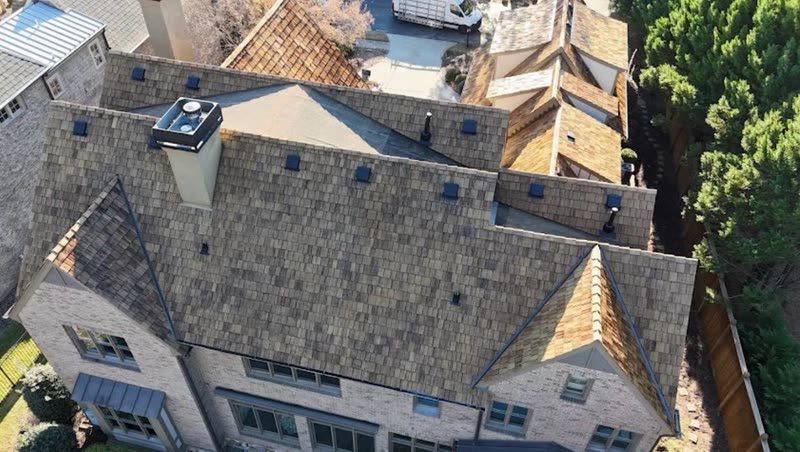 Aerial view of a home combining cedar shake and designer shingle with standing seam accents