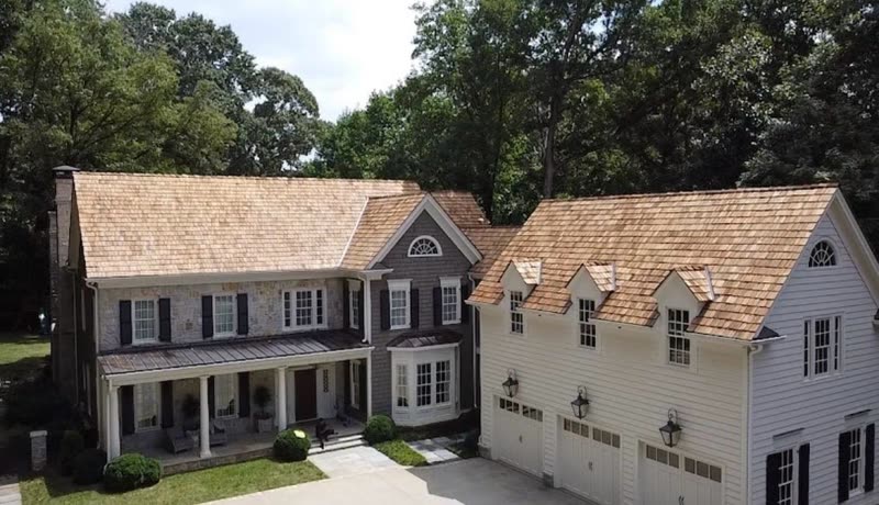 Colonial home with a completed cedar shake roof over the house and garage wing