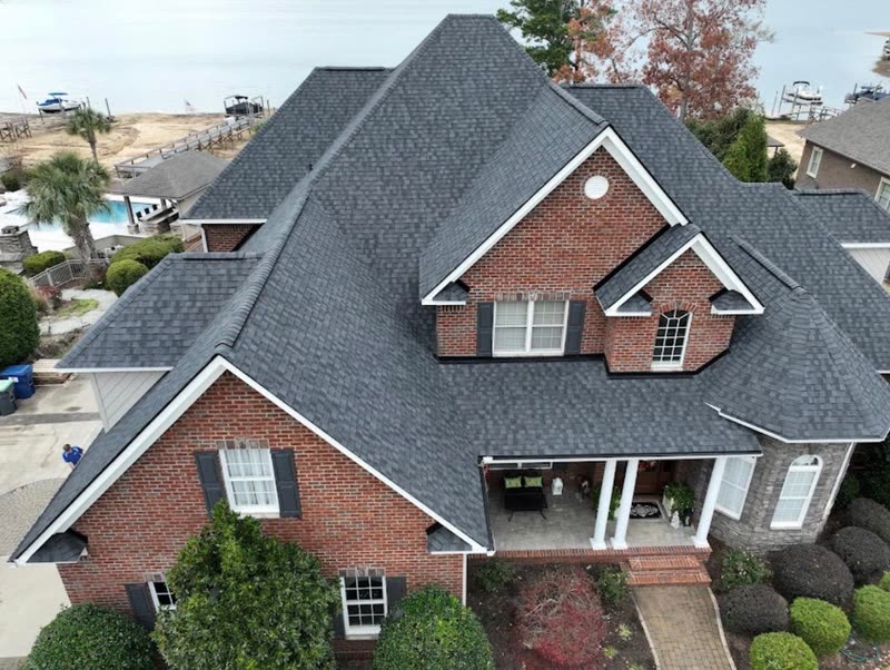 Brick home front elevation with a completed shingle roof, gables and dormer