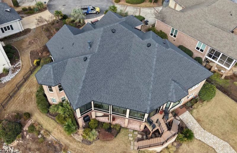 Large hip roof on a brick ranch home finished in new architectural shingle
