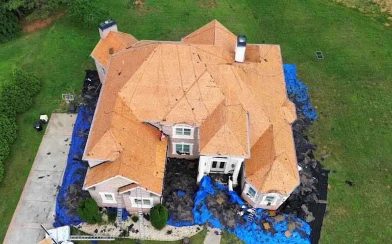House stripped completely to bare decking, ground fully tarped for the tear-off
