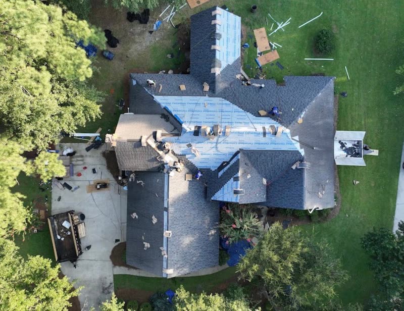 Tear-off underway with tarps protecting the patio, planting and lawn below